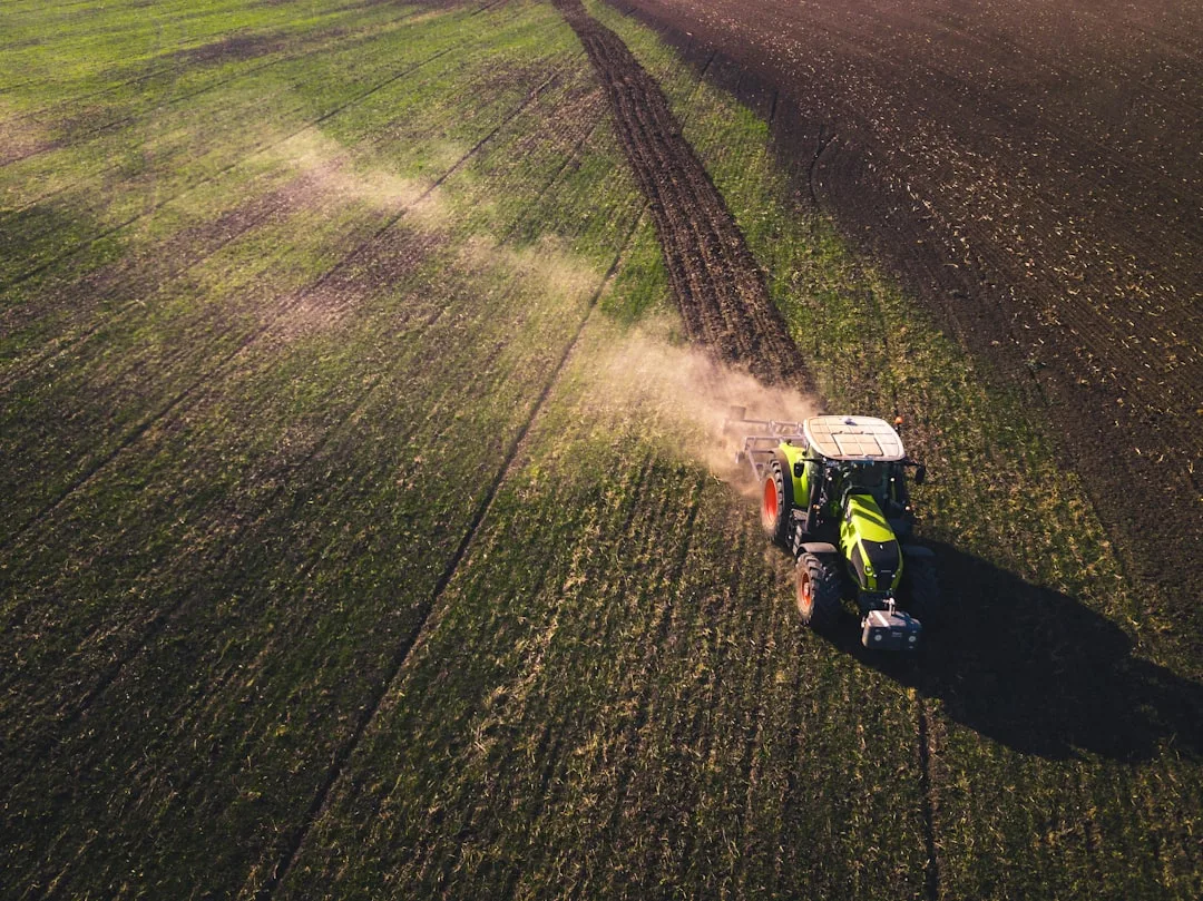 Farmer operating cover crop drill in cornfield for EQIP cost-share